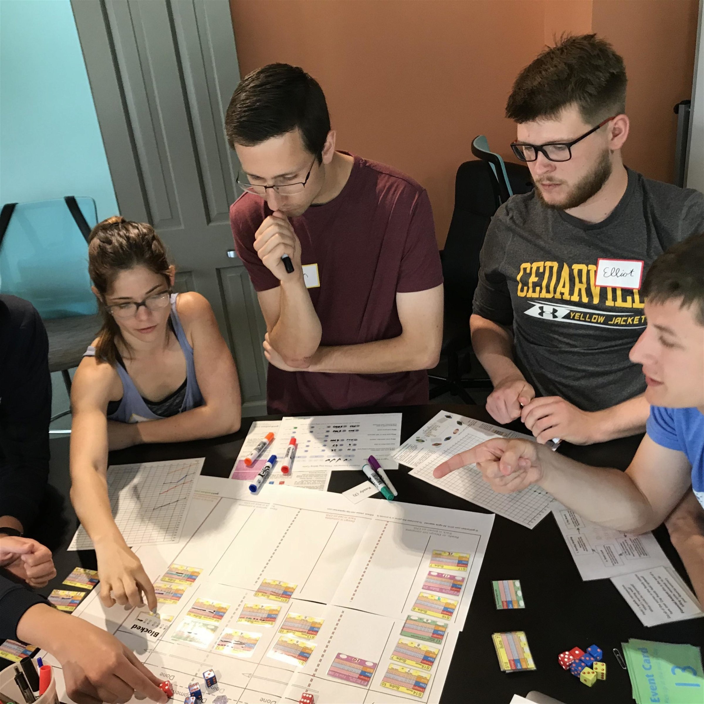 Natalia works with her team to win a Kanban simulation game.